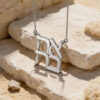 925 sterling silver stacked Ahava Hebrew love necklace resting on travertine stone