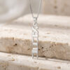 Sterling silver Custom Hebrew Name Necklace with a vertical Hebrew name pendant reading Ahava (אהבה), Hebrew for love resting on a travertine stone