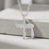 Sterling silver Hebrew Chai necklace with cubic zirconia stones, hanging on a gray stone block