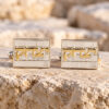 Sterling silver Western Wall cufflinks with the Hebrew name Yitzhak in gold, displayed on Jerusalem stone
