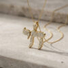 14K yellow gold pavé diamond Chai necklace resting on travertine stone