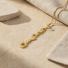 Close up of a 24K gold plated Custom Hebrew Name Necklace, handmade Hebrew name pendant reading Juliet (ג'ולייט) on a stone surface