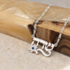 Sterling silver Hebrew name necklace with Star of David resting on olive wood and stone