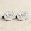 Engraved sterling silver cufflinks with a Hebrew name and Jerusalem stone texture on cream linen