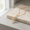 24K gold plated Israel map necklace with Nano Bible resting on travertine stone