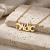 24K gold plated custom Hebrew script name necklace on stone with linen