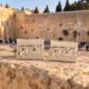 Sterling silver Hebrew name Kotel cufflinks displayed in front of the Western Wall in Jerusalem
