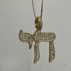 14K yellow gold pavé diamond Chai necklace close-up on a grey background