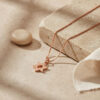 Tiny rose gold Star of David necklace on travertine stone