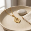 24K gold plated Hebrew flame necklace reading האש שלי (My Fire) in a stone dish
