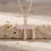 Rose gold plated sterling silver Hebrew Chai pendant with cubic zirconia stones, on travertine stone