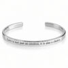 Sterling silver cuff bracelet engraved with an English quote about love, on a white background