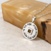 Sterling silver Nano Bible Eshet Chayil Necklace leaning on an amber stone block, Hebrew Eshet Chayil engraving and nano Bible chip