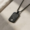 Black stainless steel dog tag necklace on travertine, side angle of the Hebrew Psalm 23 engraving and Star of David