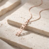 Rose gold plated Custom Hebrew Name Necklace with rose gold chain draped over a stone block, personalized Hebrew name pendant reading Ahava (אהבה), Hebrew for love