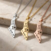 Three Israel map necklaces in silver, gold and rose gold with Magen David, displayed on stone