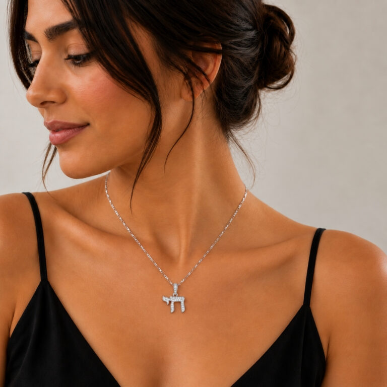 Woman in a black top wearing a sterling silver cubic zirconia Hebrew Chai pendant necklace