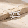 Silver Hebrew name necklace with a heart accent on a light stone background, custom Israeli name jewelry