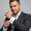 Man in a tailored suit wearing custom sterling silver Hebrew name cufflinks on his French cuffs