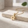 Gold plated tiny Star of David pendant detail on a stone block