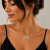 Woman in a black top wearing the sterling silver Hebrew name necklace with Star of David and birthstone