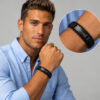 Man wearing a black braided leather bracelet with a black engraved nameplate, with a close-up of the men's bracelet on the wrist