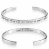 Two sterling silver cuff bracelets showing a Hebrew blessing engraved outside and a name and date engraved inside