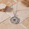 Sterling silver Nano Bible Eshet Chayil Necklace hanging over stone tiles, showing the Hebrew Eshet Chayil engraving