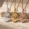 Sterling silver, gold and rose gold Hebrew flame necklaces hanging from a stone block
