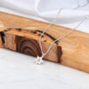 Dainty silver Star of David necklace on a wooden slab, minimalist Jewish necklace