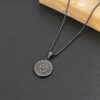 Stainless steel compass pendant on a box chain against a dark textured background