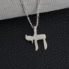 Sterling silver cubic zirconia Chai pendant on a figaro chain against black leather