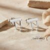 Sterling Silver Hebrew Chai earrings displayed with natural stone and burlap, handcrafted Israeli Judaica