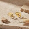 24K Gold Plated Hebrew Chai stud earrings on travertine stone, refined gold Jewish jewelry