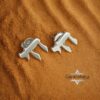 Sterling Silver Chai stud earrings on warm desert sand, Israel-inspired Hebrew earrings