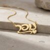 14K gold personalized Hebrew name necklace with heart charm on stone background