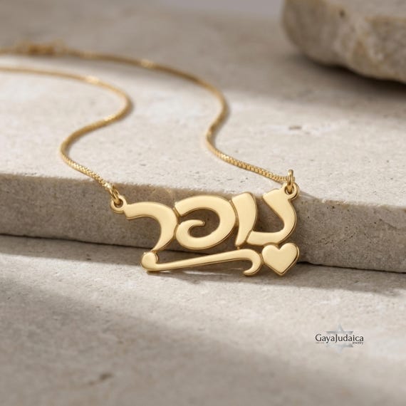 14K gold personalized Hebrew name necklace with heart charm on stone background