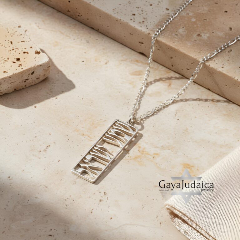 Elegant sterling silver Shema Israel tag necklace engraved with Hebrew prayer, displayed on a soft stone background – ha