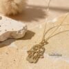 14K gold Hamsa pendant necklace on elegant chain – handmade Jewish evil eye protection jewelry photographed on soft ston