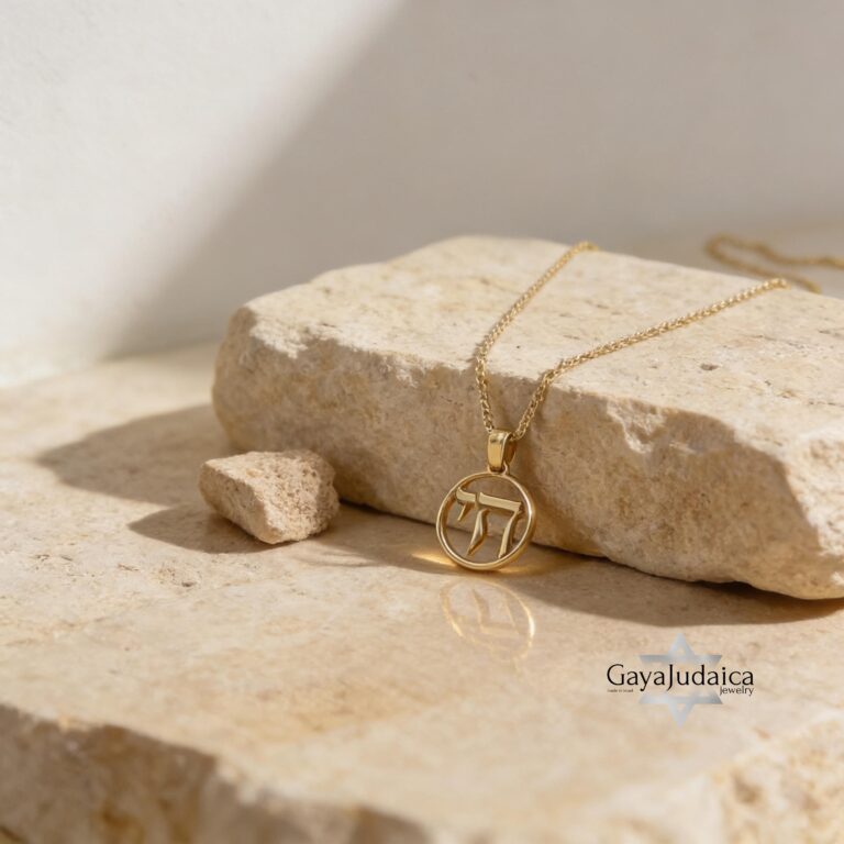 A mini round Chai pendant crafted in solid 14K gold, featuring the Hebrew Chai symbol, representing life and faith. A ha