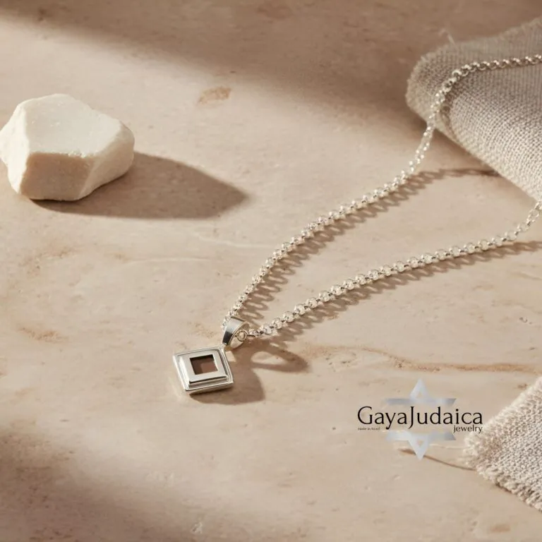 Sterling silver Nano Bible necklace featuring the entire Tanakh on a microchip pendant, displayed on a soft beige backgr