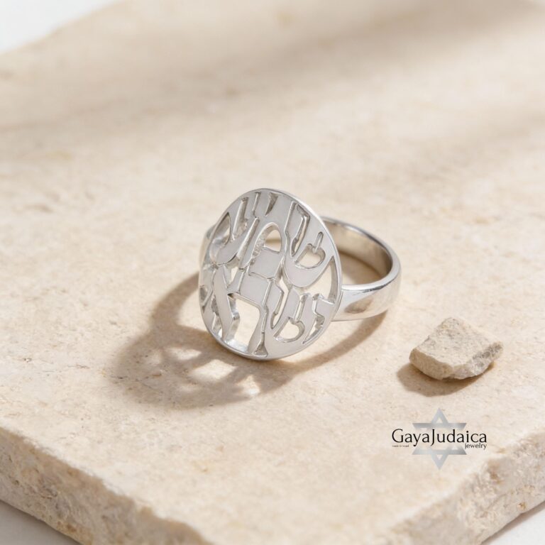 May include: A silver ring featuring a cut-out design of the Hebrew letter 'Chai' in a heart shape.