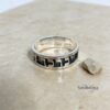 May include: A silver ring with a black enamel inlay featuring the Hebrew words "Chai", which means "life