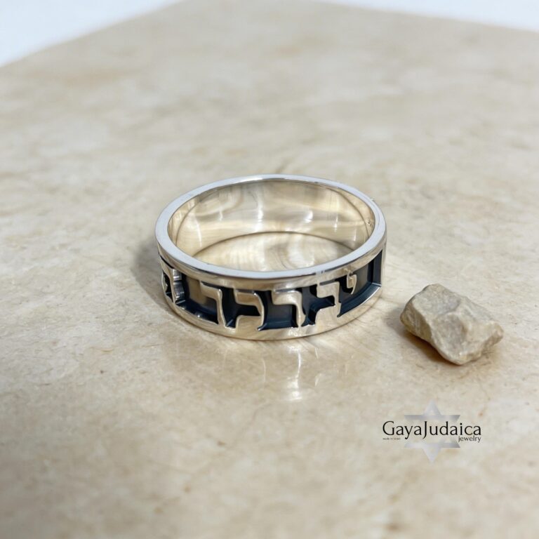 May include: A silver ring with a black enamel inlay featuring the Hebrew words "Chai", which means "life