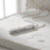 Engraved Hebrew bar necklace in sterling silver on a stone surface