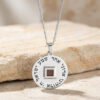 Silver Shema Yisrael nano Bible pendant with engraved Hebrew prayer resting on a sandstone block