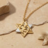 Two-tone Shema Yisrael Star of David pendant on a gold-plated chain on beige travertine