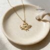 Gold Am Yisrael Chai necklace in a ceramic dish with linen