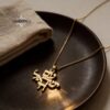 14K gold Am Yisrael Chai necklace on a dark plate