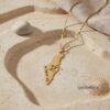 14K gold Israel map pendant on sand with linen